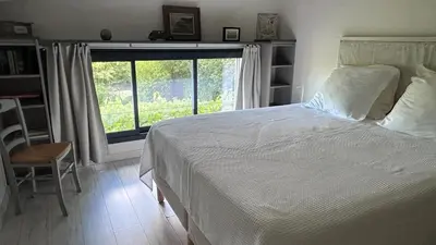 a bedroom with a large bed and a window at L'ancien poulailler- The Old Hen House in Saint-Saturnin-les-Apt