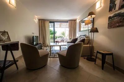 a living room with chairs and a couch and a television at L'ancien poulailler- The Old Hen House in Saint-Saturnin-les-Apt