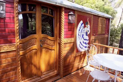 a cabin with a wooden door and a table on a deck at Appel du Luberon in Mérindol