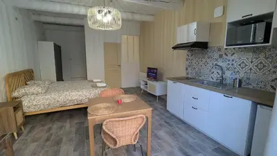 a bedroom with a bed and a kitchen with a table at Studio centre de Charleval in Charleval