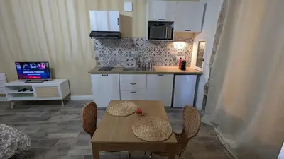 a kitchen with a table and chairs and a kitchen with a counter at Studio centre de Charleval in Charleval