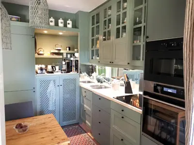 a kitchen with white cabinets and a table in it at Aix centre, 2 room apartment garden, parking in Aix-en-Provence