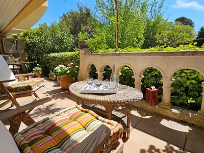 a patio with chairs and a table with glasses on it at Aix centre, 2 room apartment garden, parking in Aix-en-Provence