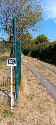 a sign on the side of a road next to a fence at Maison provençale de charme in Velaux