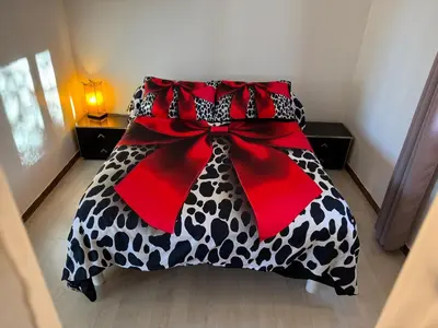 a bed with a black and white blanket with a red bow at Maison provençale de charme in Velaux