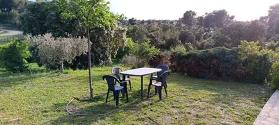 a table and four chairs in a field at Maison provençale de charme in Velaux