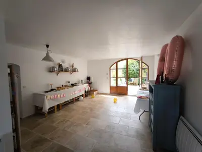 a kitchen with a table and a sink in a room at Le Mas des iscles Mallemort in Mallemort
