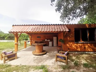 a log cabin with two benches in front of it at Le Mas des iscles Mallemort in Mallemort