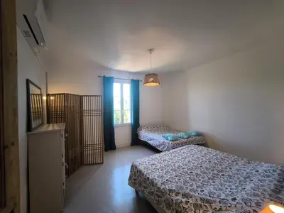 a bedroom with two beds and a window at Le Mas des iscles Mallemort in Mallemort