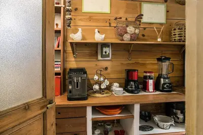 a wooden cabinet with a coffee maker on a shelf at Mas des Olivades - Ferme Provençale - Piscine in Pernes-les-Fontaines