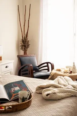 a bedroom with a bed with a book and a chair at Mas des Olivades - Ferme Provençale - Piscine in Pernes-les-Fontaines