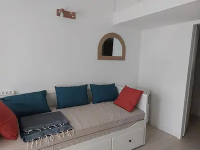 a couch with red and blue pillows in a room at Studio 25m2 in LʼIsle-sur-la-Sorgue