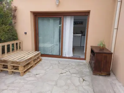 a porch with a bench and a sliding glass door at Studio 25m2 in LʼIsle-sur-la-Sorgue
