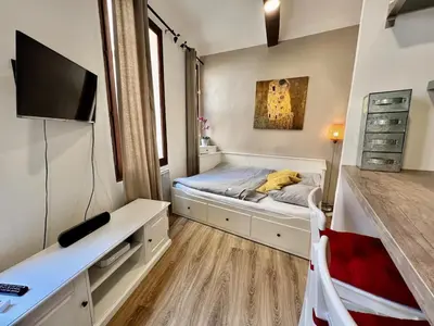 a small bedroom with a bed and a tv at Bel Appartement dans le centre d'Aix-en-Provence in Aix-en-Provence
