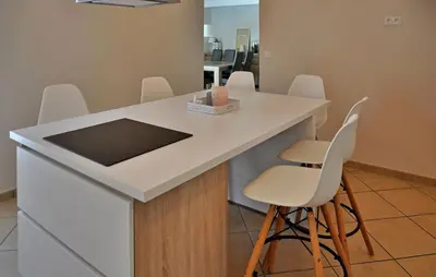 a kitchen with a white counter and white chairs at villa in Châteauneuf-de-Gadagne