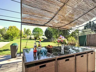 an outdoor bar with two bottles of alcohol on a table at Gîte en Provence entre Pernes les fontaines et St Didier proche l'isle sur sorgues face Mont Ventoux Villa avec piscine in Saint-Didier