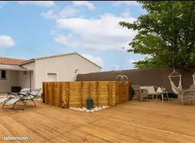 a backyard with a wooden fence and chairs and a table at Gîte en Provence entre Pernes les fontaines et St Didier proche l'isle sur sorgues face Mont Ventoux Villa avec piscine in Saint-Didier