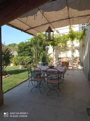 a patio with a table and chairs under an umbrella at La Bartavelle in Eyragues