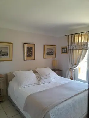 a bedroom with a large white bed and a window at La Bartavelle in Eyragues