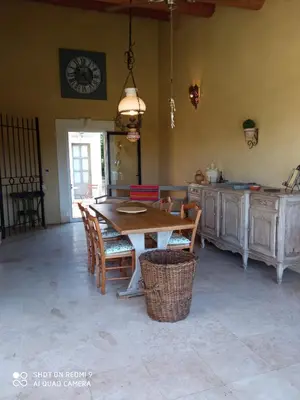a kitchen with a table and chairs and a clock on the wall at La Bartavelle in Eyragues
