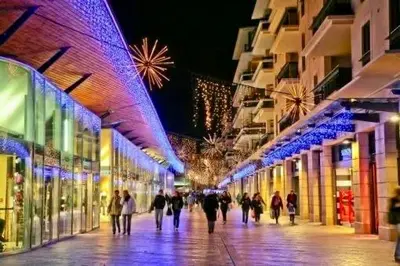 a group of people walking down a street at night at Le Aix Rotonde Mirabeau - Centre Ville Terrasse Garage in Aix-en-Provence