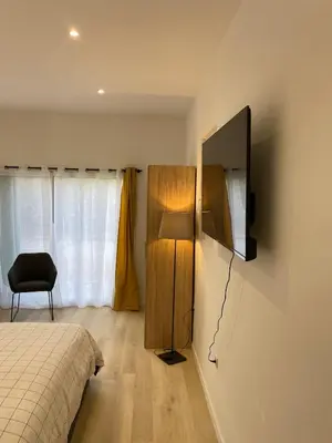 a bedroom with a bed and a television on the wall at Studio en Provence avec piscine in La Barben