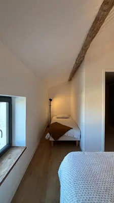 a bedroom with a bed and a window at Le Granier location in Robion en Luberon
