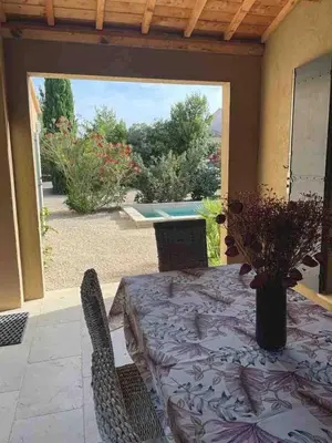 a patio with a table and chairs and a pool at Petite maison au calme avec piscine privative in Saint-Rémy-de-Provence