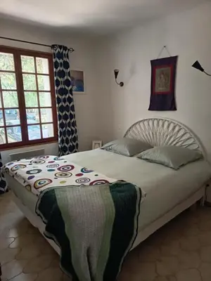 a bedroom with a large bed with a blanket on it at fleur de gaïa chambres d'hôtes in Mazan