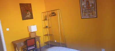 a bedroom with a yellow wall with a mirror at fleur de gaïa chambres d'hôtes in Mazan