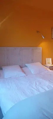 a large bed with white sheets in a bedroom at fleur de gaïa chambres d'hôtes in Mazan