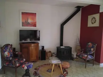 a living room with chairs and a television and a table at fleur de gaïa chambres d'hôtes in Mazan