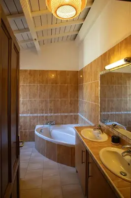 a bathroom with two sinks and a bath tub at Domaine de la Myrtille in Pertuis