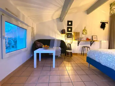 a bedroom with a bed and a table in a room at MAYA l Studio l Super Wifi & Parking Gratuit l Vue Panoramique Sainte-Victoire in Aix-en-Provence