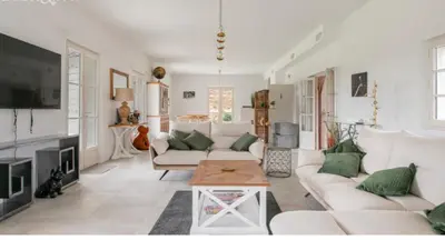 a living room with white furniture and green pillows at les Claveaux in Montfuron