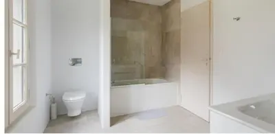 a white bathroom with a tub and a toilet at les Claveaux in Montfuron