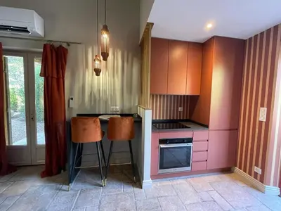 a kitchen with pink cabinets and orange stools at Mazet Arlequine in Eygalières