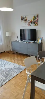a living room with a television and a table and chairs at Aix centre charmant T2 climatisé parc jourdan in Aix-en-Provence