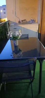 a glass table with a vase with flowers on it at Aix centre charmant T2 climatisé parc jourdan in Aix-en-Provence