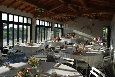 a room with white tables and chairs and windows at Bastide Saint Maurin in Ansouis