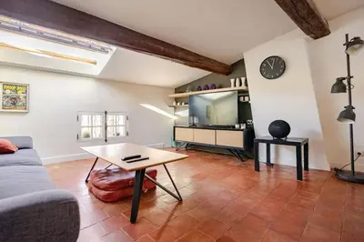 a living room with a couch and a table at Ecrin au cœur d'Aix-Vue sur la Place de la Mairie in Aix-en-Provence