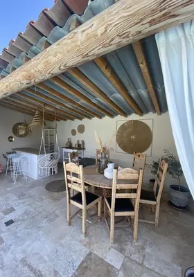 a dining room with a wooden table and chairs at La Bastide Mas in Le Thor