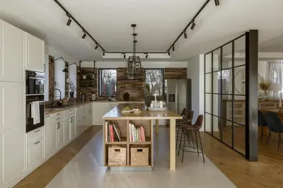 a kitchen with white cabinets and a counter with chairs at La Bastide Mas in Le Thor