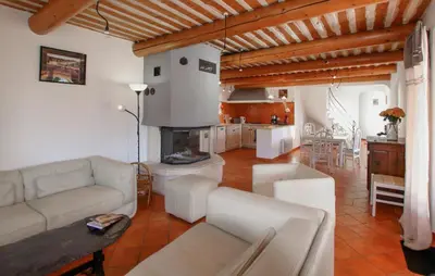 a living room with a couch and a table and a kitchen at Sarriette & Romarin in Apt