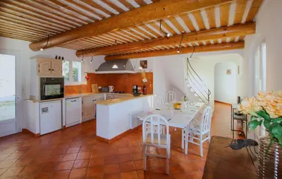 a kitchen with a table and chairs in a room at Sarriette & Romarin in Apt
