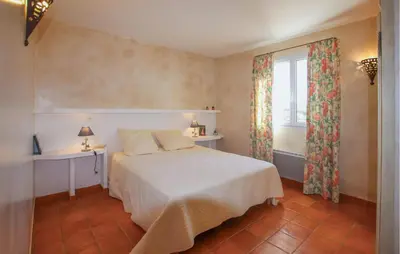 a bedroom with a bed and a window at Sarriette & Romarin in Apt