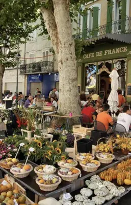 a table filled with lots of food in front of a building at Le Coeur de L'Isle, Cosy, Hypercentre, Clim, Wifi, TV, Netflix in LʼIsle-sur-la-Sorgue