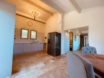 a large kitchen with a table and a refrigerator at La Réserve Provence in Vaugines