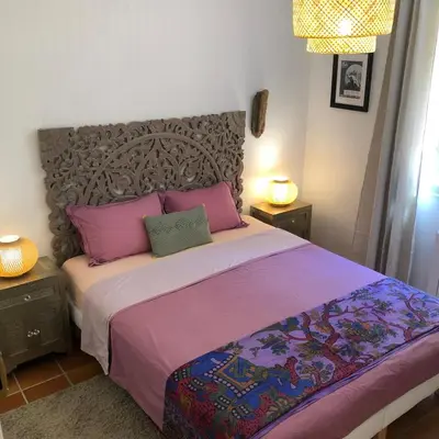 a bedroom with a large bed with pink and purple sheets at villa spacieuse piscine jacuzzi 8 chambres 16 couchages in Saint-Chamas
