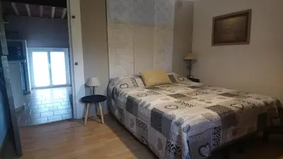 a bedroom with a bed with a table and a window at Complexe dans un grand Mas Provençal en campagne avec piscine privée in Monteux